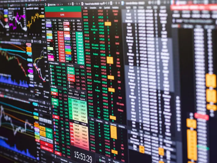 Graphique boursier de l'action Teleperformance sur un écran, avec bougies vertes et rouges.